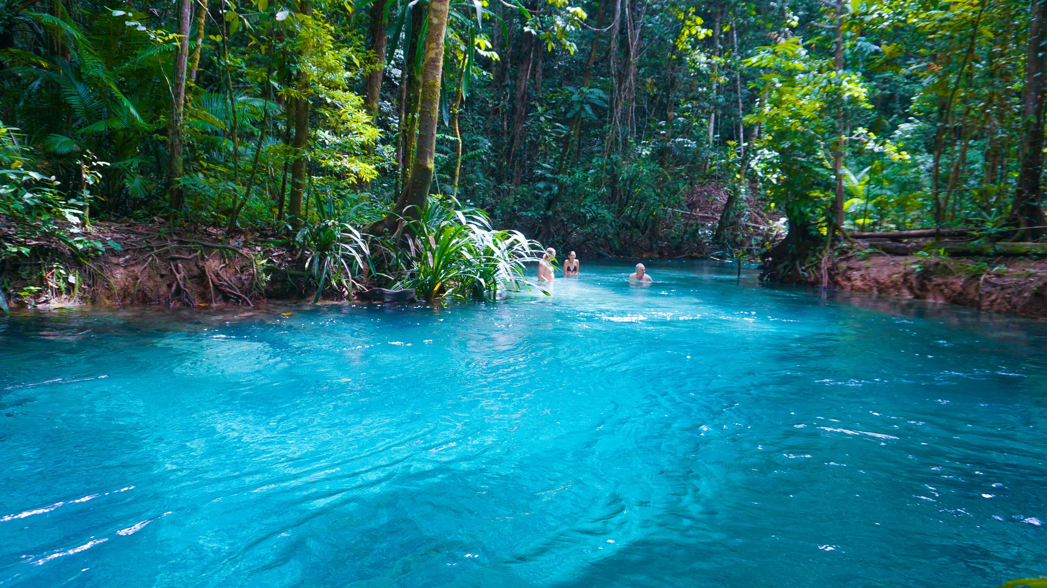 three people at the blue river