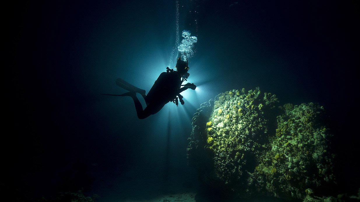 diver with lights in underwater